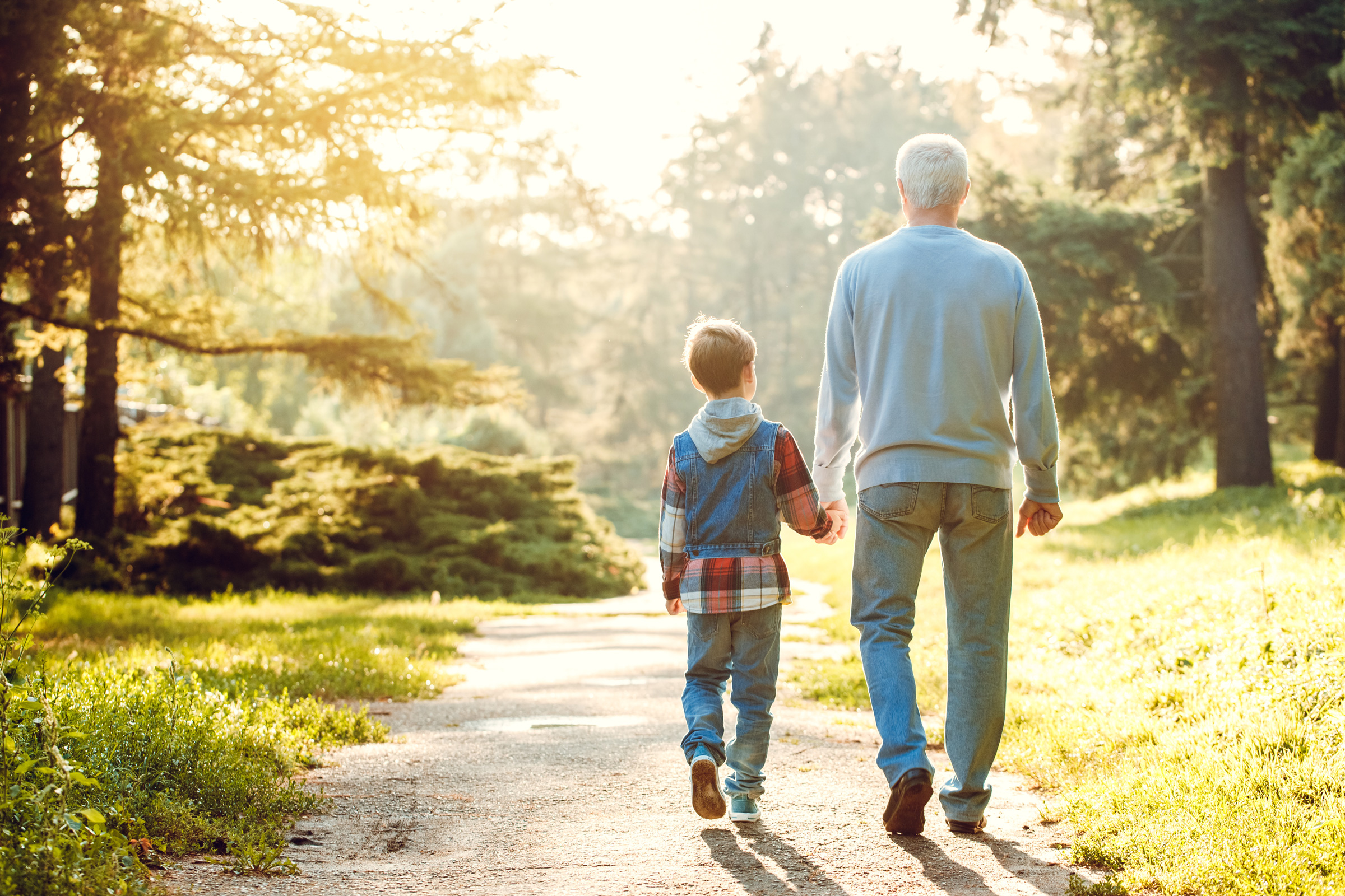 A grandfather walking with his grandson, comfortable with his retirement planning from Fund Direct Advisors